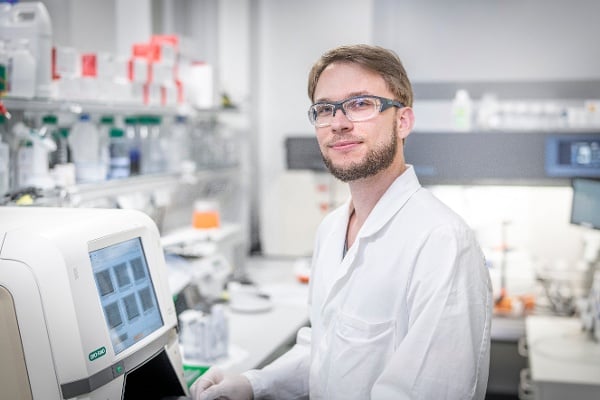 Scientist working on a machine in an AGC Biologics lab.